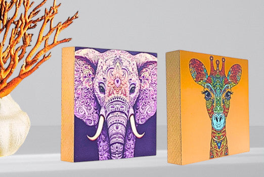 Zwei Holzbilder aus der Serie Mandala auf einem Regal.