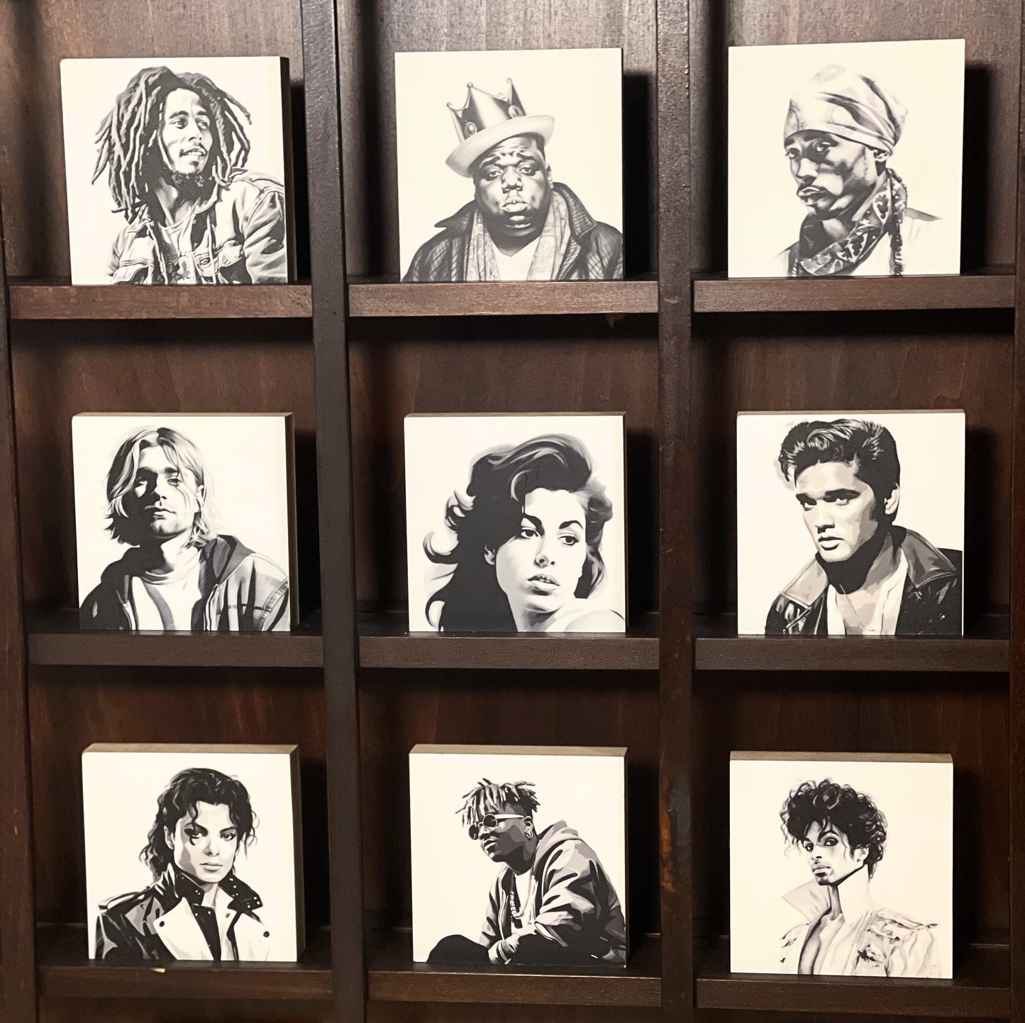 Alle neun Holzbilder der Kollektion Famous dead singers in einem Regal aus dunklem Holz.