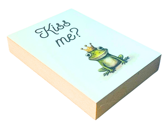 Liegende Ansicht Holzbild mit weißem Hintergrund, darauf eine Illustration eines Frosches mit Krone und die Schrift Kiss me?