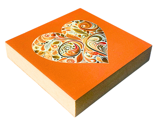 Liegende Ansicht Holzbild mit Herz aus floralen Mustern in Orange, Gelb und Weiß auf orangem Hintergund