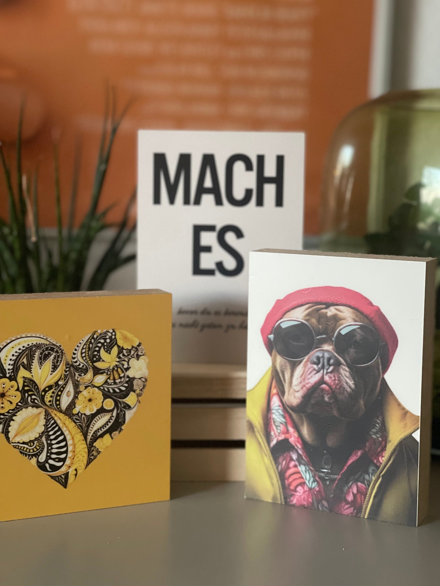 Mehrer Holzbilder auf einem Schrank mit anderen Deko-Elementen