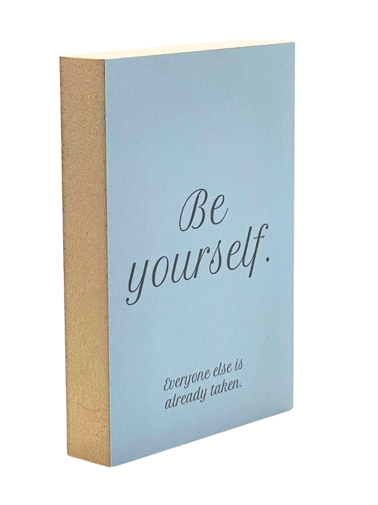 Holzbild 8,5 x 12 com mit schwarzer Schrift auf blaugrauem Hintergrund "Be yourself. Everyone else is already taken."