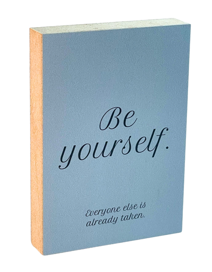 Holzbild 8,5 x 12 cm mit schwarzer Schrift auf blaugrauem Hintergrund "Be yourself. Everyone else is already taken."