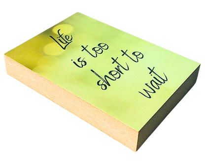 Liegende Ansicht Holzbild mit dem Text "Life is too short to wait" auf gelb gemustertem Hintergrund.